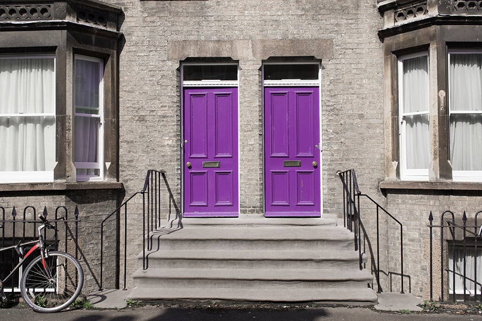 兩扇相同的紫色木門，灰色外觀